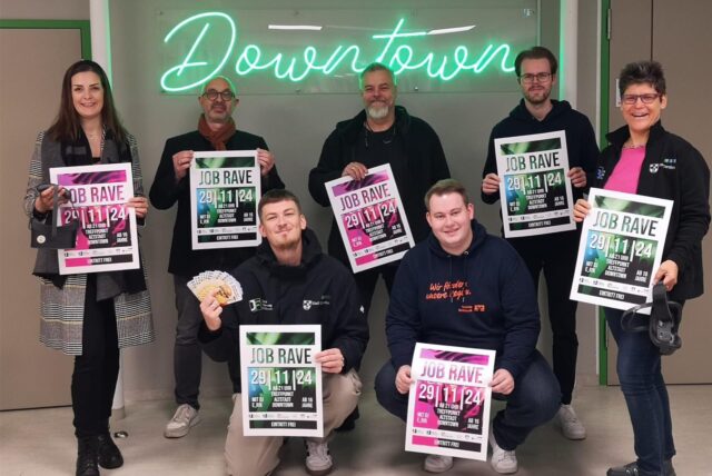 Die Veranstalter des Job-Raves halten Plakate der Veranstaltung in den Händen.