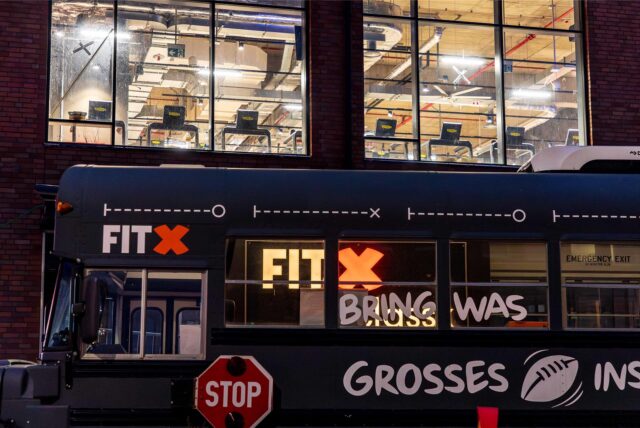 Vor dem FitX-Studio in den Hertener Höfen parkte in der Dämmerung ein grauer Bus.