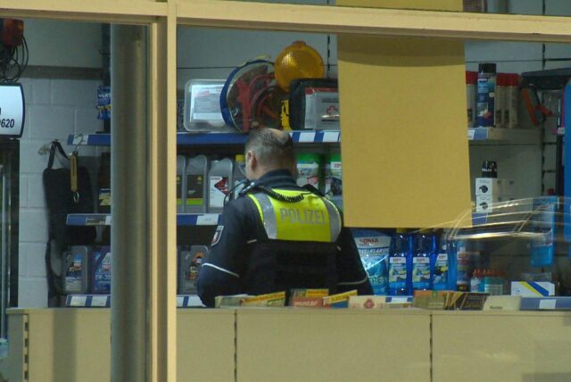 Ein Polizist in einer Tankstelle in Oespel. Dort war am Montag ein Mann mit einer Schussverletzung aufgetaucht.