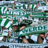Fans von Werder Bremen halten Schals in die Höhe (Archivbild).