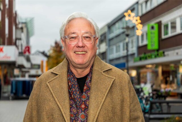 Der Hertener FDP-Sprecher und Rechtsanwalt Andreas Hebestreit im hellbraunen Wintermantel lächelt in die Kamera. Hinter ihm ist unscharf die Fußgängerzone in der Hertener Innenstadt zu erkennen.