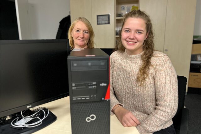 Antje Arbeiter und Theresa Schulte-Huxel sitzen vor einem Refurbished Computer.