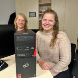 Antje Arbeiter und Theresa Schulte-Huxel sitzen vor einem Refurbished Computer.