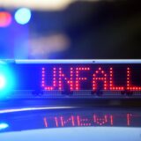 Auf einem Polizeifahrzeug warnt eine Leuchtschrift vor einer Unfallstelle.