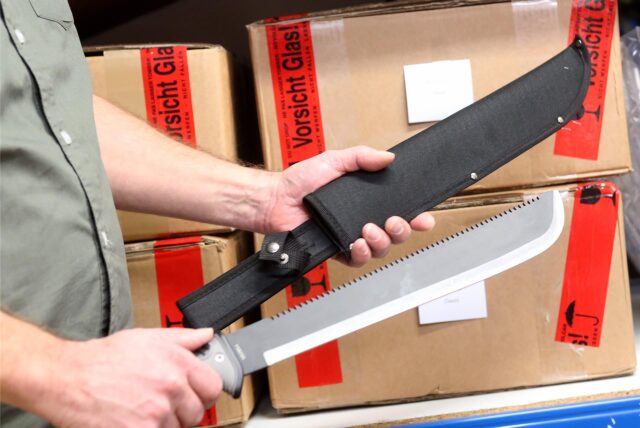 Jemand hält eine Machete in der Hand.