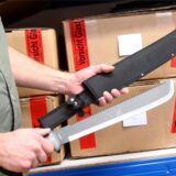 Jemand hält eine Machete in der Hand.