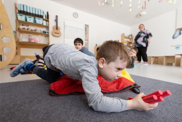 Kinder einer Kindergartengruppe nehmen an einer Bewegungseinheit teil.