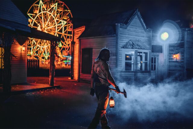 Ein Halloween-Monsterdarsteller läuft mit einer Axt durch den Movie Park Germany.