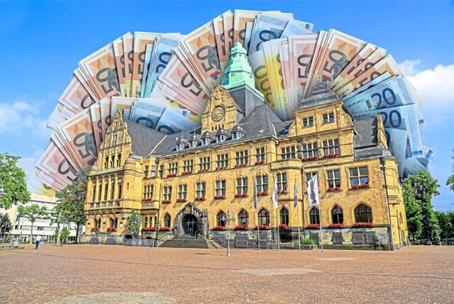 Montage zeigt das Recklinghäuser Rathaus, umrahmt von Geldscheinen