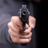 Eine Schusswaffe ist auf die Kamera gerichtet