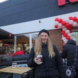 Frau vor dem neueroffneten Rewe-Markt in Castrop-Rauxel – im Hintergrund ein Grill, Luftballons