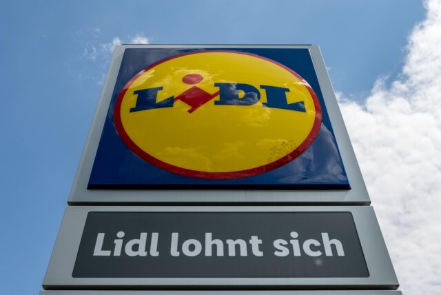 Eine Stele mit dem Logo des Discounters Lidl steht vor einer Filiale.
