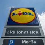 Eine Stele mit dem Logo des Discounters Lidl steht vor einer Filiale.
