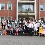 Eine Gruppe von etwa 30 Menschen, in der Mitte Hertens Bürgermeister Matthias Müller, steht anlässlich der feierlichen Einbürgerung vor dem Hertener Rathaus.