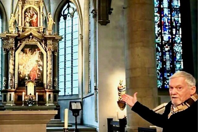 Werner Koppe weist auf den Altar in der Recklinghäuser Petruskirche.