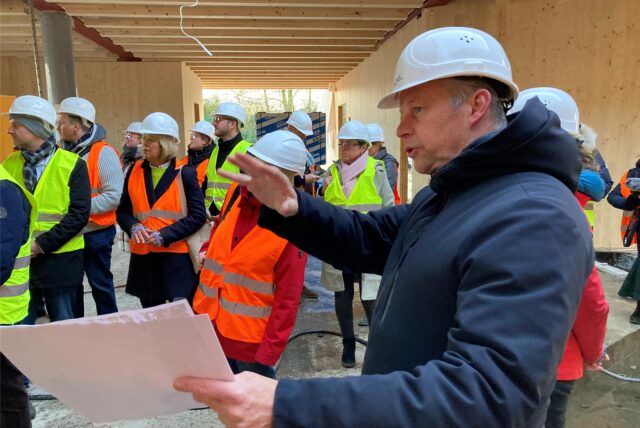 Projektleiter Marc Schiek vom Architektenbüro ACMS erklärt den Mitgliedern des Schulausschusses die Vorteile der Holzbauweise der neuen Goetheschule an der Hervester Straße in Marl.