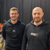 Zoran Tilev und Denis Wachsmann stehen neben einer Reihe von Renn-Motorrädern.
