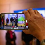 Eine Hand mit einem Smartphone geht bei der Preisverleihung der Vestischen Pioniere in Recklinghausen in die Höhe