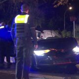 Polizisten stehen neben einem beschädigten Auto.