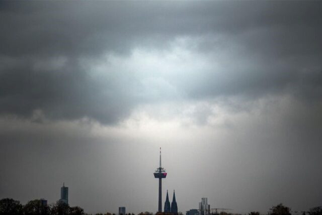Wolken ziehen am Morgen über den Kölner Dom und den Fernsehturm.