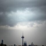 Wolken ziehen am Morgen über den Kölner Dom und den Fernsehturm.