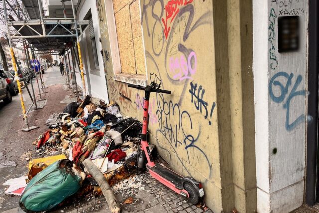 Die Mallinckrodtstraße am Samstagnachmittag. Vor einem Haus sind Spuren eines Brandes in einer Wohnung zu sehen, der ein Todesopfer gefordert hat.