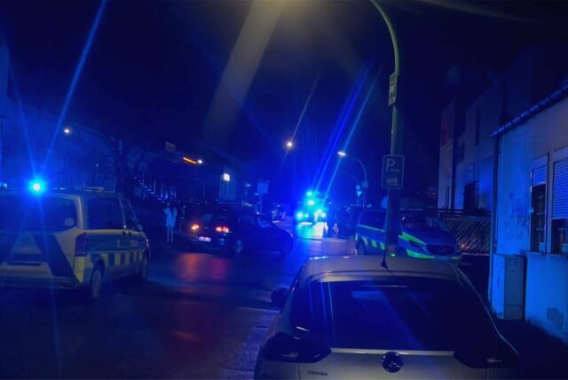 Polizeiwagen stehen mit Blaulicht an einer Straße.