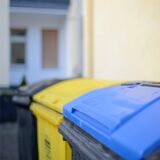 Detailaufnahme einer Blauen Tonne, dahinter eine gelbe Tonne unscharf im Bild.