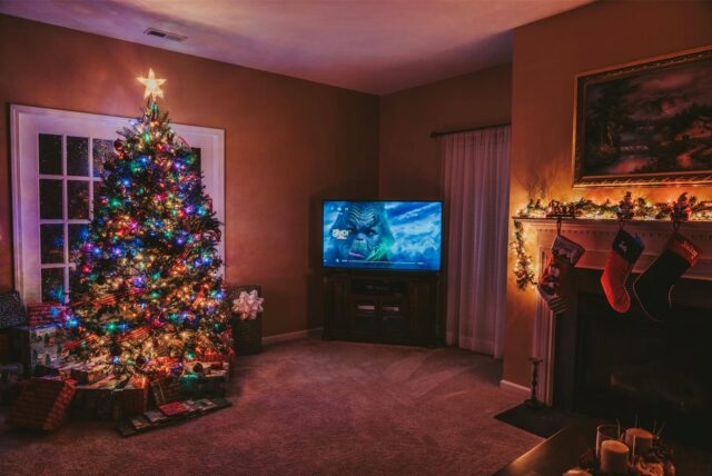 In einem weihnachtlich geschmückten Wohnzimmer läuft ein Weihnachtsfilm.
