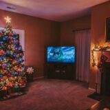 In einem weihnachtlich geschmückten Wohnzimmer läuft ein Weihnachtsfilm.