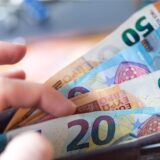 Symbolbild: Eine Frau hält ein Portemonnaie mit Geldscheinen in der Hand.