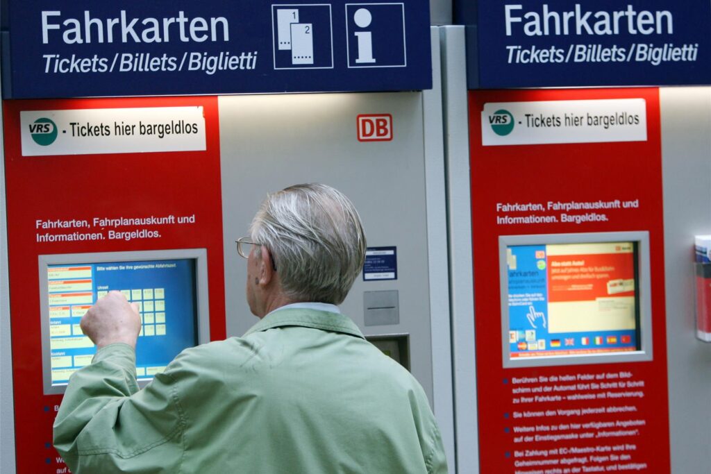 Ein Mann steht vor einem Fahrkartenautomaten der Deutschen Bahn. Ein Mann steht vor einem Fahrkartenautomaten der Deutschen Bahn.