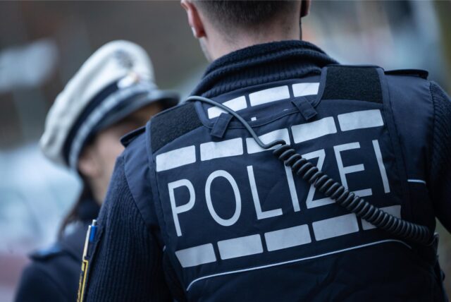 Eine Polizistin (l) und ein Polizist gehen im Rahmen eines Fototermins eine Straße entlang (gestellte Szene)