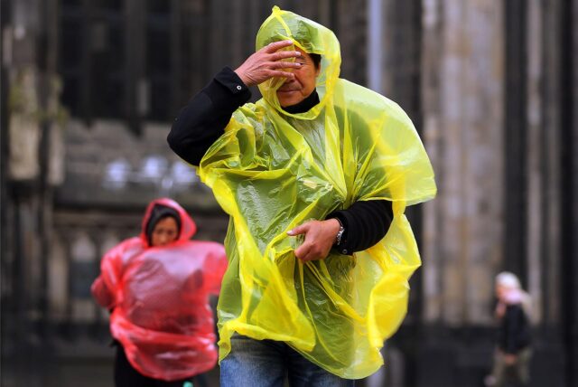 Touristen mit Regenumhängen