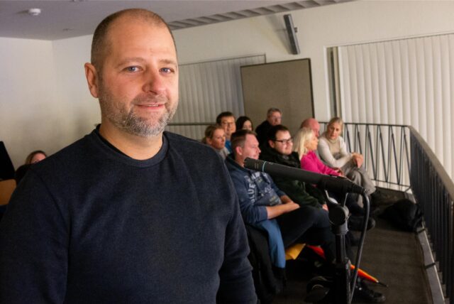 Alexander Fischer aus Herten im blauen Pulli auf der Besuchertribüne des Sitzungssaals im Hertener Rathaus. Im Hintergrund sind weitere Besucher der Schulausschuss-Sitzung erkennbar.