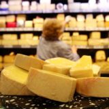 Mehrere Stücke Käse liegen auf der Käsetheke in einem Supermarkt.