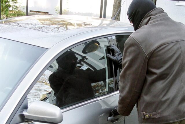 Symbolbild: Ein Dieb greift an den Türgriff eines Autos.