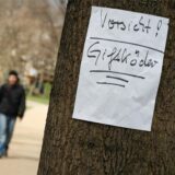 „Vorsicht! Giftköder“ steht auf einem Schild, das an einem Baum angebracht ist.