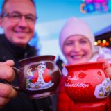 Ein Paar hält zwei Tassen mit heißem Glühwein kurz nach der Eröffnung des „Santa Pauli“ Weihnachtsmarkt“ auf dem Spielbudenplatz.