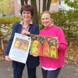 Gudrun Gabriel und Friederika Haase präsentieren den neuen Adventskalender 2024 des Lions Clubs Dorsten-Wulfen.