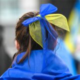 Eine Teilnehmerin der Demonstration «Das Licht wird die Dunkelheit besiegen» hat eine Schleife in den Nationalfarben der Ukraine in den Haaren