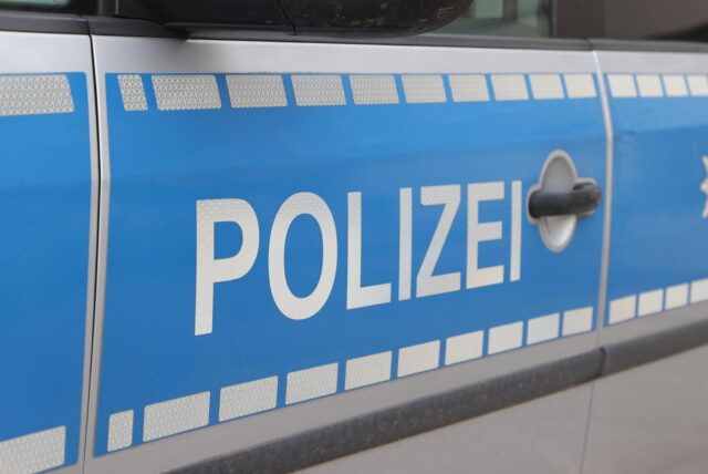 Polizei steht auf der Tür eines Streifenwagens.