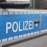 Polizei steht auf der Tür eines Streifenwagens.