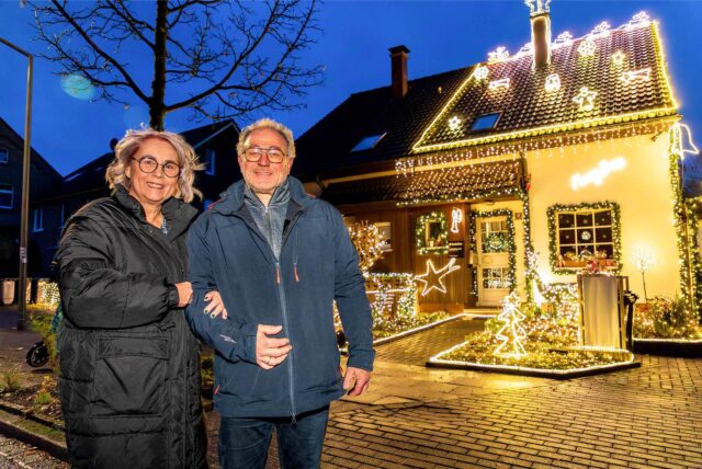 Ingrid und Michael Eilingsfeld stehen in der Dämmerung vor ihrem Haus in Herten-Scherlebeck, das mit Lichtschläuchen sowie zahlreichen beleuchteten Figuren geschmückt ist.
