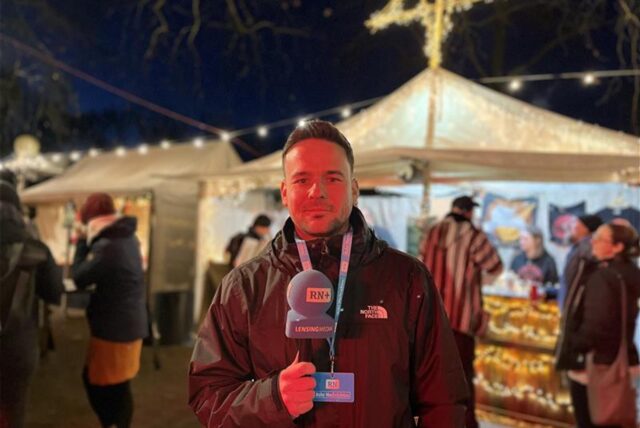 RN-Reporter Martin Bytomski steht vor der Lichterkulisse des Weihnachtsmarktes im Fredenbaumpark in Dortmund.