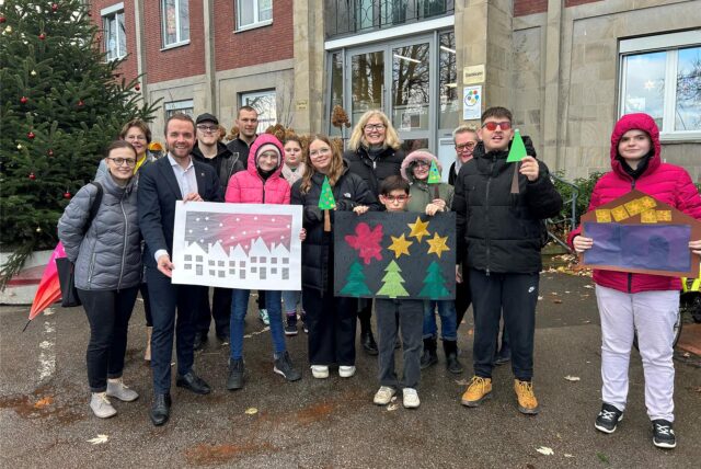 Viele Personen stehen vor dem Waltroper Rathaus und zeigen Bilder aus Pappe und Transparentpapier.