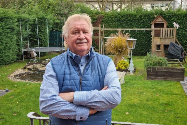 Wolfgang Werner steht in seinem Garten.