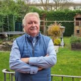 Wolfgang Werner steht in seinem Garten.