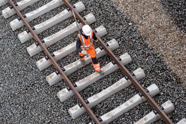Ein Arbeiter geht über eine noch nicht fertige Gleisanlage der Bahn.
