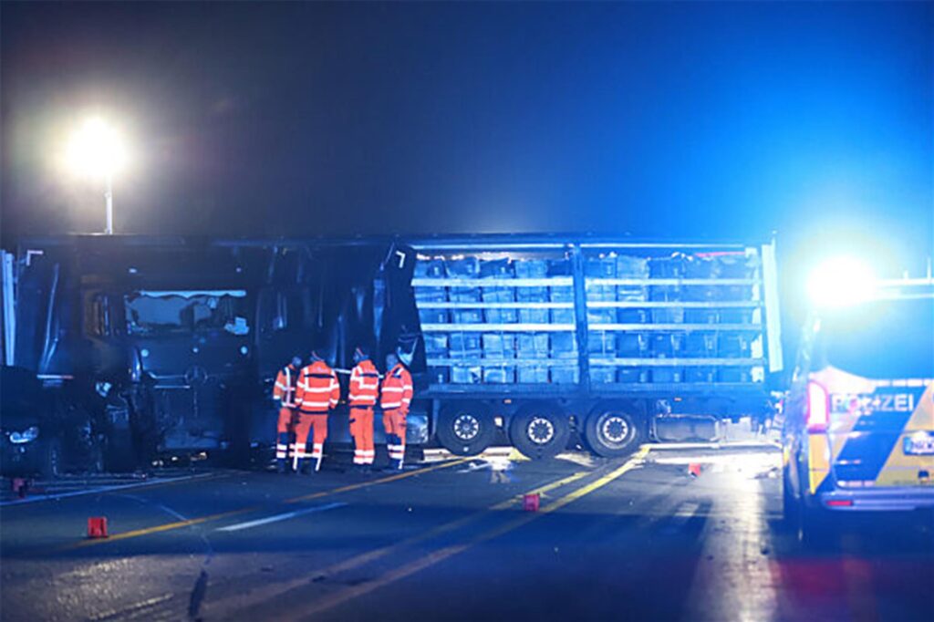 Einsatzkräfte stehen neben einem Lastwagen auf der Autobahn 1
